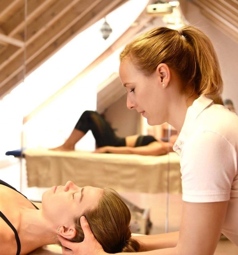 Katja Bernecker, KabeO Osteopathie Heppenheim, craniosacrale Therapie Katja Bernecker, KaBeO Osteopathie Heppenheim behandelt eine Patientin am Kopf auf der Liege